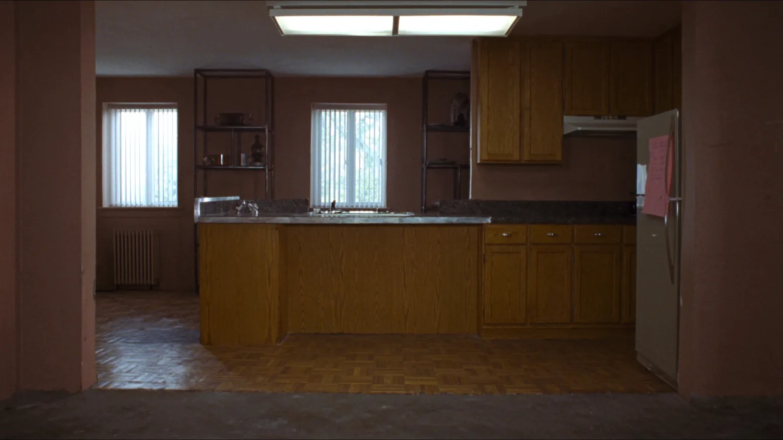 Dated 1980s Bellevue kitchen before remodel — golden-oak laminate cabinets and worn Formica counters